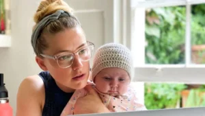 Amber Heard smiling and holding her daughter Oonagh after a 10K race victory.
