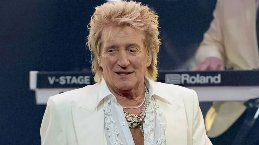 Rock icon Rod Stewart performing under bright lights before experiencing an on-stage medical emergency.