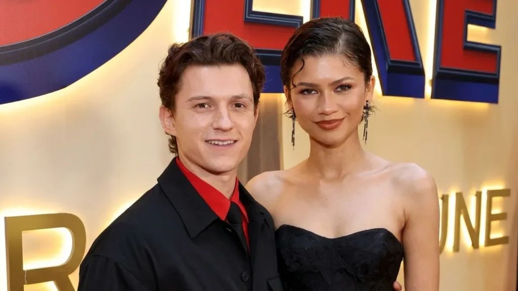 Tom Holland and Zendaya standing together in matching Louis Vuitton outfits at the Spider-Man premiere.